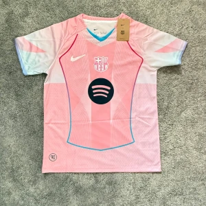 Barça Lamine Yamal rosa matchtröja Nike M - Säljer en FC Barcelona fotbollströja från Nike i rosa och ljusblå toner, med Lamine Yamal och nummer 10 på ryggen. Tröjan har korta ärmar, Dri-FIT-material och klubbmärke framtill. Spotify-logga på bröstet och snygga grafiska detaljer.