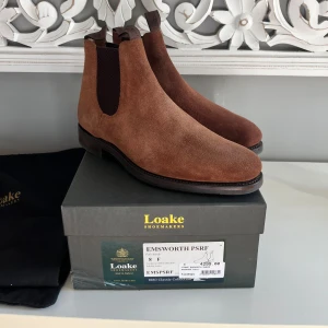 Loake ChelseaBoots + Skoblock - Säljer ett par Chelsea boots från loake helt nya. Medföljer skoblock och dustbags. Helt oanvända!