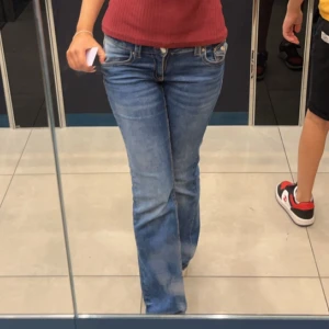 Blå bootcut jeans med låg midja - Säljer ett par klassiska blå jeans med bootcut och låg midja. Perfekta för dig som gillar en avslappnad och trendig stil. Storlek 170.