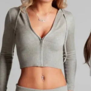 Grå croppad hoodie med dragkedja - Snygg grå croppad hoodie med dragkedja framtill och snörning i huvan. Jätte fin och helt oanvänd. Står S men skulle säga xs