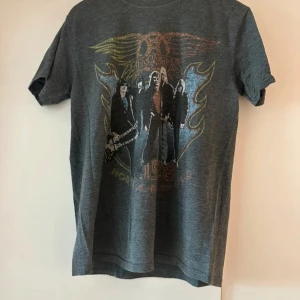 Snygg Aerosmith Tröja - Jag säljer min Aerosmith tröja, dels pga att den tyvärr inte passar mig längre och dels pga flytt. Jag har använt tröjan en del så trycket kan vara lite slitet samt att det sticker ut en liten tråd baktill uppe vid nacken (se bilder). Men i övrigt är tröjan i bra skick.