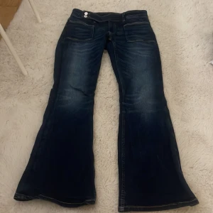 Bootcut jeans från Gina Tricot blå - Mörkblå bootcut jeans från Gina Tricot i storlek 164. Jeansen har två framfickor med markerade sömmar. Klassisk denim-look med snygg tvätt och breda ben nertill.