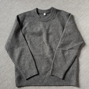 Uniqlo - Grå stickad tröja från Uniqlo - Mysig grå stickad tröja från Uniqlo med rund halsringning och ribbade muddar. Perfekt för lager-på-lager under kyliga dagar. Enkel och stilren design som funkar till allt. Ganska liten i storleken. 