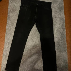 Svarta skinny jeans från Dsquared2 - Svarta jeans från Dsquared2 Äkta. med klassisk femficksdesign och tydlig logga på bakfickan. Byxorna har en tight passform och raka ben, tillverkade i stretchigt jeansmaterial för en snygg siluett. Perfekta för dig som gillar stilrena och moderna jeans. 