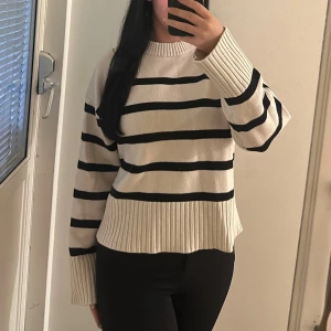 Randig stickad tröja i beige och svart - Säljer en stickad tröja med breda svarta ränder på beige botten. Storlek S använd fåtal gånger och i bra skick.