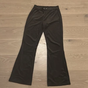 Mörk bruna bootcut mjukis byxor från Gina Tricot - Mörkbruna bootcut byxor från Gina Tricot i mjukt och stretchigt material. Saknar snöre.