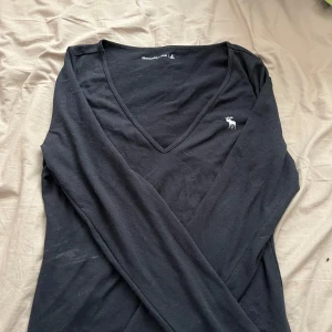 Svart v-ringad tröja Abercrombie & Fitch - Svart långärmad tröja från Abercrombie & Fitch med v-ringning och liten vit logga på bröstet. Väldigt mjuk å skön i tyget. Pris kan diskuteras 