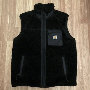 Carhartt Väst - Tjena, säljer nu denna svarta Carhartt väst i storlek S-M, Skick mycket bra 9,5/10. Alldeles perfekt till dig som vill ha ett varmt bekvämt, men endå stilrent kombinationsplagg nu till hösten🍁. PM vid frågor eller funderingar 🤝