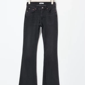 Svarta bootcut jeans med låg midja - Snygga svarta jeans med bootcut-modell och hög midja. Jeansen har klassisk femficksdesign, dragkedja och knapp framtill. Perfekta för dig som vill ha en tidlös och trendig look.