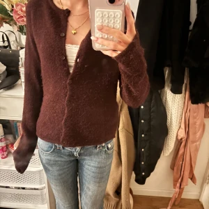 Mörkbrun kofta från Gina Tricot XS - Supermysig vinröd kofta från Gina Tricot i  stickat material. Koftan har knappar framtill, lång ärm och en klassisk rund halsringning. Perfekt att slänga över ett linne eller t-shirt för en chill look. Perfekt färg till hösten