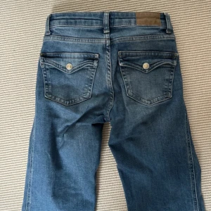 90’s bootcut jeans - Snygga blå bootcut jeans från lager 157  modell 90’s Bootcut. Klassisk femficksdesign med knappar på bakfickororna och en snygg, ljus tvätt. Jeansen har normal passform och är tillverkade i mjukt denimtyg för en avslappnad look. Som referens är jag runt 170 cm lång. Är i storlek xxs men passar mycket mer som en xs