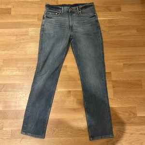 Blå raka jeans från Denim & Denim - Snygga blå jeans från Denim & Denim med klassisk femficksdesign och raka ben. Jeansen har normal midja, kopparfärgade nitar och knapp, samt diskreta slitningar för en cool look. Perfekta för dig som gillar en enkel och tidlös stil.