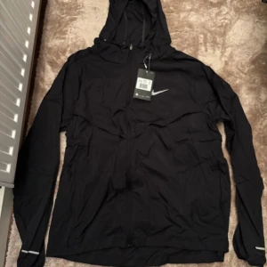 Svart Nike Miller strl M - Svart vindjacka från Nike Miller och hel dragkedja framtill. Jackan har reflekterande detaljer på ärmar och rygg samt Nike-logga. Tillverkad i lätt polyester, perfekt för blåsiga dagar. Kom privat för fler bilder eller frågor aktiv varje dag‼️‼️