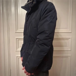J Lindberg vinterjacka  - Snygg mörkblå parkajacka med hög krage och stora fickor och perfekt för vinter ( nypris 4000 kr )