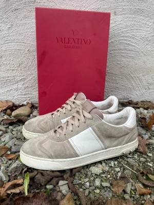 Valentino Garavani sneakers rosa/vit - Snygga Valentino Garavani sneakers i rosa mocka med vita skinnpaneler och coola nitar på baksidan.(några saknas) Kommer med originalkartong. Hör av dig vid frågor