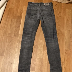 Replay grå jeans slim fit - Snygga grå jeans från Replay med klassisk femficksdesign och coola slitningar. Jeansen är 9/10 i skick. Modellen har smal passform och raka ben, det är storlek 12 år alltså ungefär 150/154