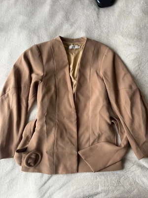 Stylein figursyd kavaj/topp - Camel färgad kavaj/topp. Ärmarna är vida och gör så att midjan ser mindre, super snygg!