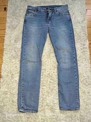 Levi's jeans 502 (nytt skick) - Nypris 1175 kr. (Oanvända)  Ett par klassiska Levi's 502 tapered fit jeans. Jeansen har en ljus färg och en rak passform. De har traditionella detaljer som många fickor och en läderlapp bak. Storlek W30 L32  Kontakta vid frågor!