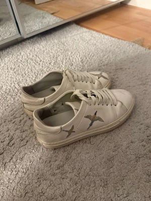 Arigatos  - Ett par vita Axel Arigatos skor i storlek 37. 