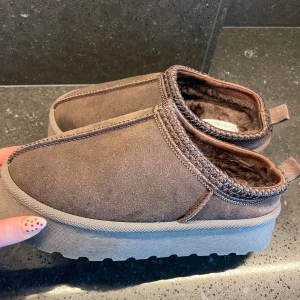 Bruna mocka ”Uggs” från Even&Odd - Säljer ett par bruna ”Uggs” från Even&odd. Skorna har rund tå och är tillverkade i mocka med stickade detaljer runt öppningen.