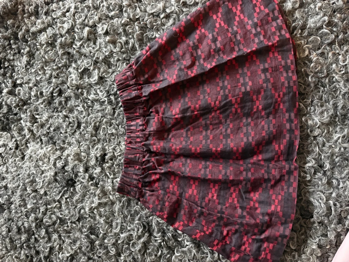 Röd rutig med svarta detaljer kortkjol från LIVLY