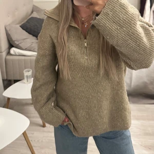 Beige stickad tröja med half zip - Säljer en beige stickad tröja med half zip och hög krage från Gina