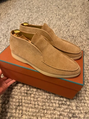 Loro Piana open walk  - Säljer ett par open walks i beige mocka med rund tå och platt sula. Skorna har en enkel slip-on design utan snörning och en ljus yttersula som matchar den mjuka mockan. Perfekta för dig som gillar en clean och avslappnad look.