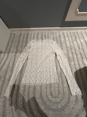 Vit långärmad spetströja - Jätte snygg långärmad spets tröja från h&m. Säljer för att den är för liten. Ganska genomskinlig. Aldrig använt bara testat 