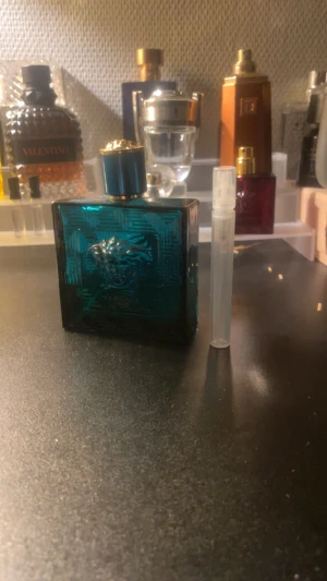 Versace Eros EdT 5 ml sample - Versace Eros Eau de Toilette i en stilren blå flaska med ikonisk Medusa-detalj. Perfekt för dig som vill sticka ut. Medföljer en praktisk provflaska för enkel testning eller att ta med på språng.