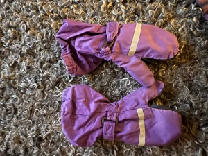 Lila vattentäta tumvantar med reflex - Säljer ett par lila vattentäta tumvantar med svart greppyta i syntetmaterial och breda reflexband över handryggen. Vantarna har resår vid handleden och justerbart band för extra passform. Perfekta för kalla dagar när du vill hålla händerna torra och varma.