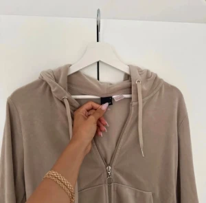 Beige velour hoodie från Gina tricot - Supermjuk beige hoodie i velour från Gina tricot. Tröjan har dragkedja framtill, huva med snörning och en stor magficka. Långärmad och croppad modell som är perfekt för en chill look.