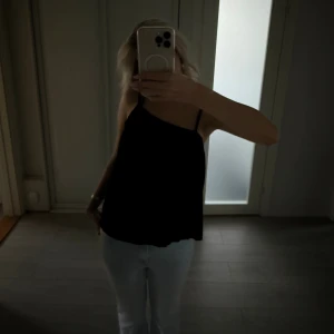 Svart linnetopp från BikBok - Säljer en svart linnetopp från BikBok i storlek S. Toppen har tunna axelband och en lös passform. Materialet är lätt och känns skönt mot huden. Enkel och stilren design som är lätt att matcha med olika outfits.