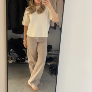 Beiga vida Jeans  - Säljer ett par beiga jeans från Gina tricot i storlek 34. Jeansen är midwaist med vida ben. Endast använd en gång så i princip i nyskick
