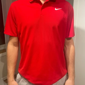 Röd Nike golf-piké  - Röd golf-piké från Nike. Andas bra och väldigt skön vid varma dagar. Kan gå ner i pris vid snabb affär!