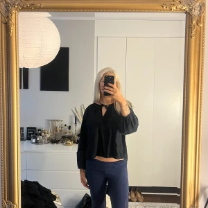 Svart blus med knyt och broderi - Svart blus från lager157  med broderade små blommor, v-ringning och knytband vid halsen. Långärmad och lite croppad model i storlek S🌸 ( använd 1 gång). 