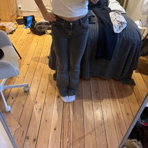 Grå jeans från Gina Tricot, bootcut - Snygga grå jeans från Gina Tricot i storlek 32. Modellen har klassisk femficksdesign, låg midja och bootcut-ben. Jeansen är i stretchigt denim som sitter skönt och ger en avslappnad look. Perfekta till sneakers eller boots.