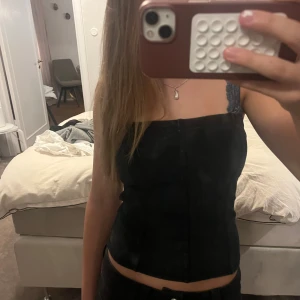 Svart tubtopp - Säljer en svart tubtopp från H&M Divided i storlek S. Toppen är sydd i mjuk manchester med smala ränder och har en bandeauformad passning. Perfekt att styla med jeans eller kjol för en cool och enkel look.