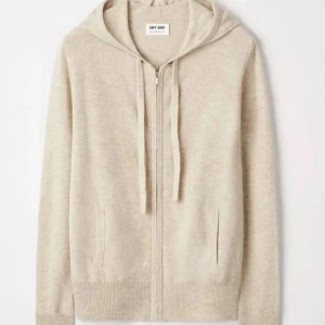 Beige hoodie i kashmir från Soft Goat - Mysig beige hoodie i mjuk kashmir från Soft Goat. Tröjan har dragkedja framtill, huva med snörning och ribbade muddar. Perfekt för dig som gillar en avslappnad och stilren look.