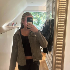 Grå jeansjacka från Sincerely Layer - Snygg grå /grön jeansjacka från Sincerely Layer med klassisk krage, två bröstfickor med knappar och raka långa ärmar. Jackan har en loose passform och är tillverkad i mjukt bomullsmaterial. Perfekt att slänga över en crop top för en chill look.