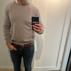 Beige stickad tröja från Oscar Jacobson Small - Snygg beige stickad tröja från Oscar Jacobson i storlek M men är small. Tröjan har rund hals, ribbade muddar och är långärmad. Perfekt för dig som gillar stilrena och klassiska plagg med skön passform.