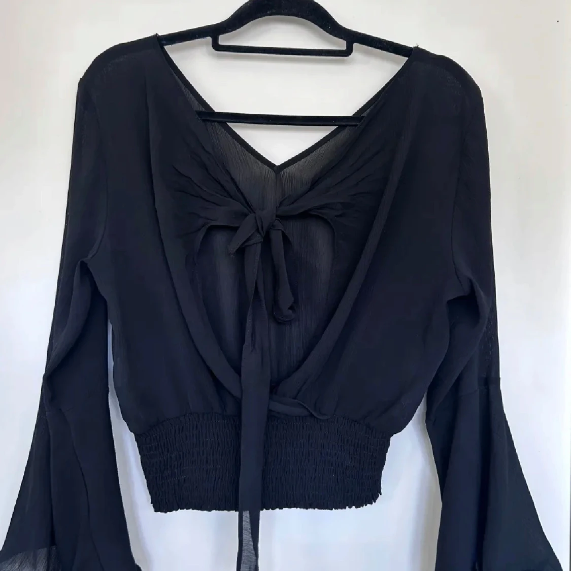 Svart blus med knyt och vida ärmar