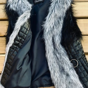 Snygg väst med fuskpäls! - Snygg tunnfodrad väst med dekorativ fuskpäls och fickor framtill i storlek L. Perfekt, tidlöst höstplagg! I nyskick.