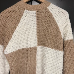 Beige och vit stickad tröja - Säljer en chunky stickad tröja från MNG i storlek XS men passar som S. Tröjan har ett blockmönster i beige och vitt, med grovstickad struktur och rund halsringning.🐻🍁🍂🥮