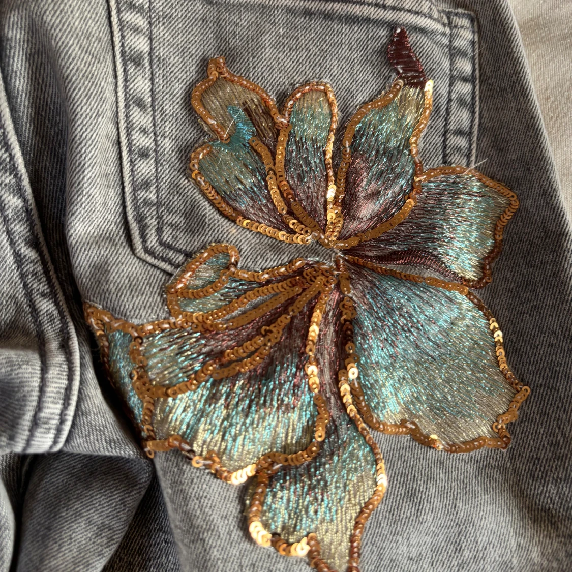 Grå bootcut jeans med paljettblommor - 1