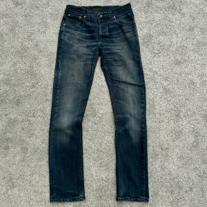 Mörkblå jeans från Nudie Jeans Co 32/34 - Säljer ett par unika Nudie jeans i färgen mörkblå. Dessa är sällsynta ”Nudie Jeans Grim Tim 11 Months Denim”. Modellen på jeansen är Grim Tim vilket är slimfit och den mest eftertraktade modellen. Mycket bra skick. Storlek W32/L34. Hör gärna av er! 😀