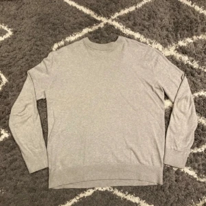 Ljusgrå tröja från 157 - En stilren ljusgrå tröja från 157 i storlek S. Tröjan har rund halsringning, långa ärmar. Mycket skönt och bra material. Jag är 180cm,67kg och den passar mig perfekt.
