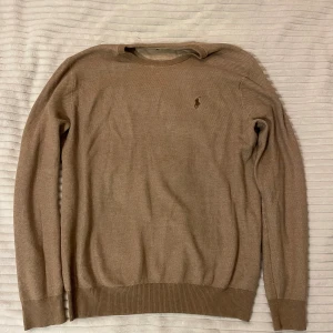 Ralph lauren tröja - Snygg beige tröja från Ralph Lauren med klassisk rund halsringning och diskret broderad logga på bröstet. Långärmad modell i mjuk bomull. Storleken är M men passar även S