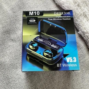 M10 True Wireless Headset - DEELIOR M10 True Wireless Headset med digital indikator, Bluetooth 5.3, ENC brusreducering och touchkontroll. Upp till 5 timmars musik, 280 timmars standby. Laddningstid ca 2 timmar. Fint skick, komplett med laddningsetui och tydlig LED-display.