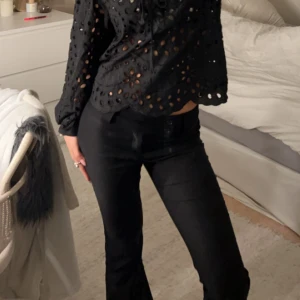 Svarta bootcut byxor från Gina Tricot - Snygga svarta bootcut byxor från Gina Tricot i storlek 34. Byxorna har hög midja, två knappar i linningen och är tillverkade i ett mjukt bomullsmaterial. Perfekta för dig som gillar en klassisk och stilren look med lite utsvängda ben.