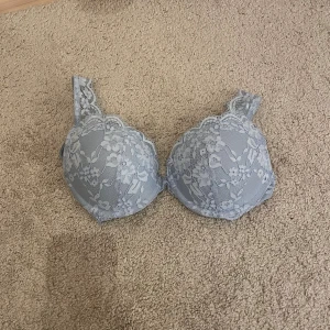 LINDEX bra 75B - Säljer en ljusblå bh från H&M i storlek 75B. Bh:n har vacker blommig spets över hela kuporna och axelbanden, vilket ger en romantisk och feminin känsla. Perfekt för dig som gillar detaljer och mjuka pastellfärger.